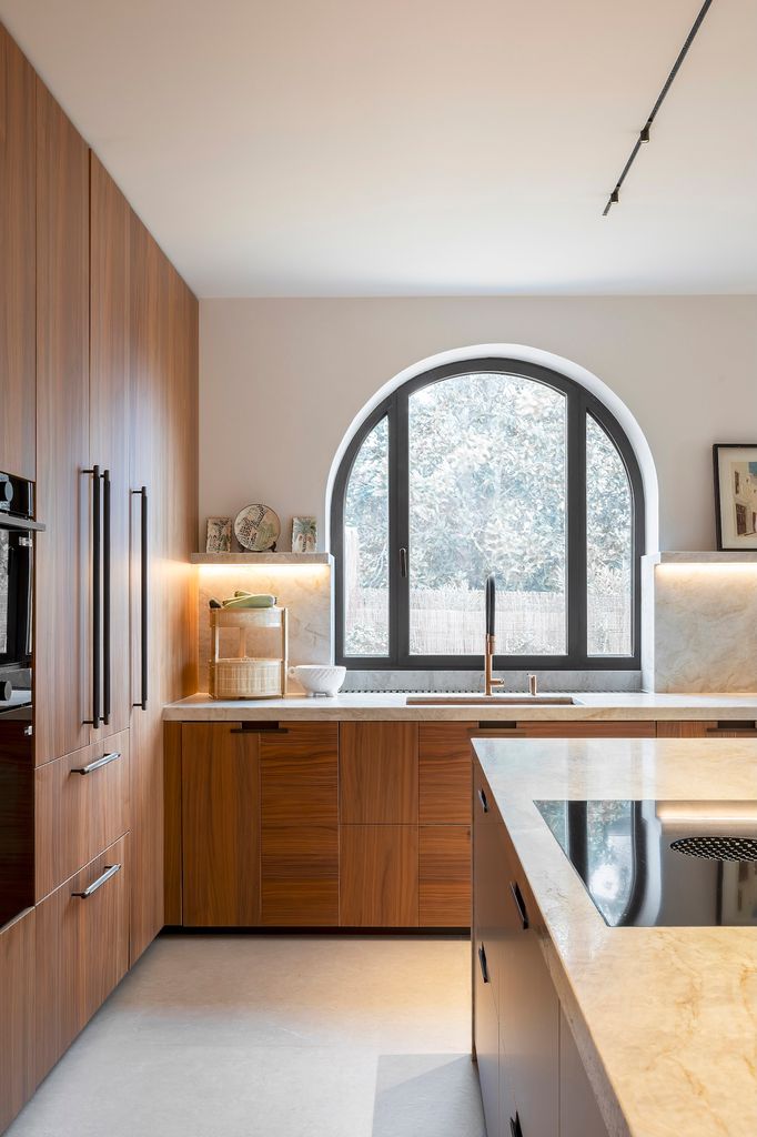 Kitchen with wooden fronts and a light stone worktop