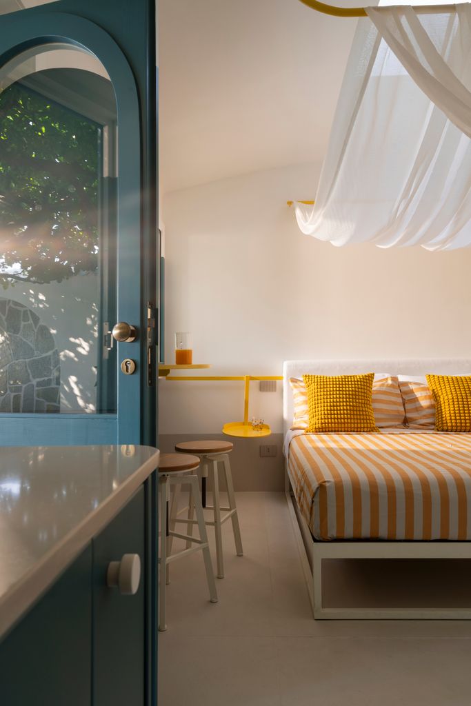 Bedroom with yellow stripes and a canopy beneath the roof window